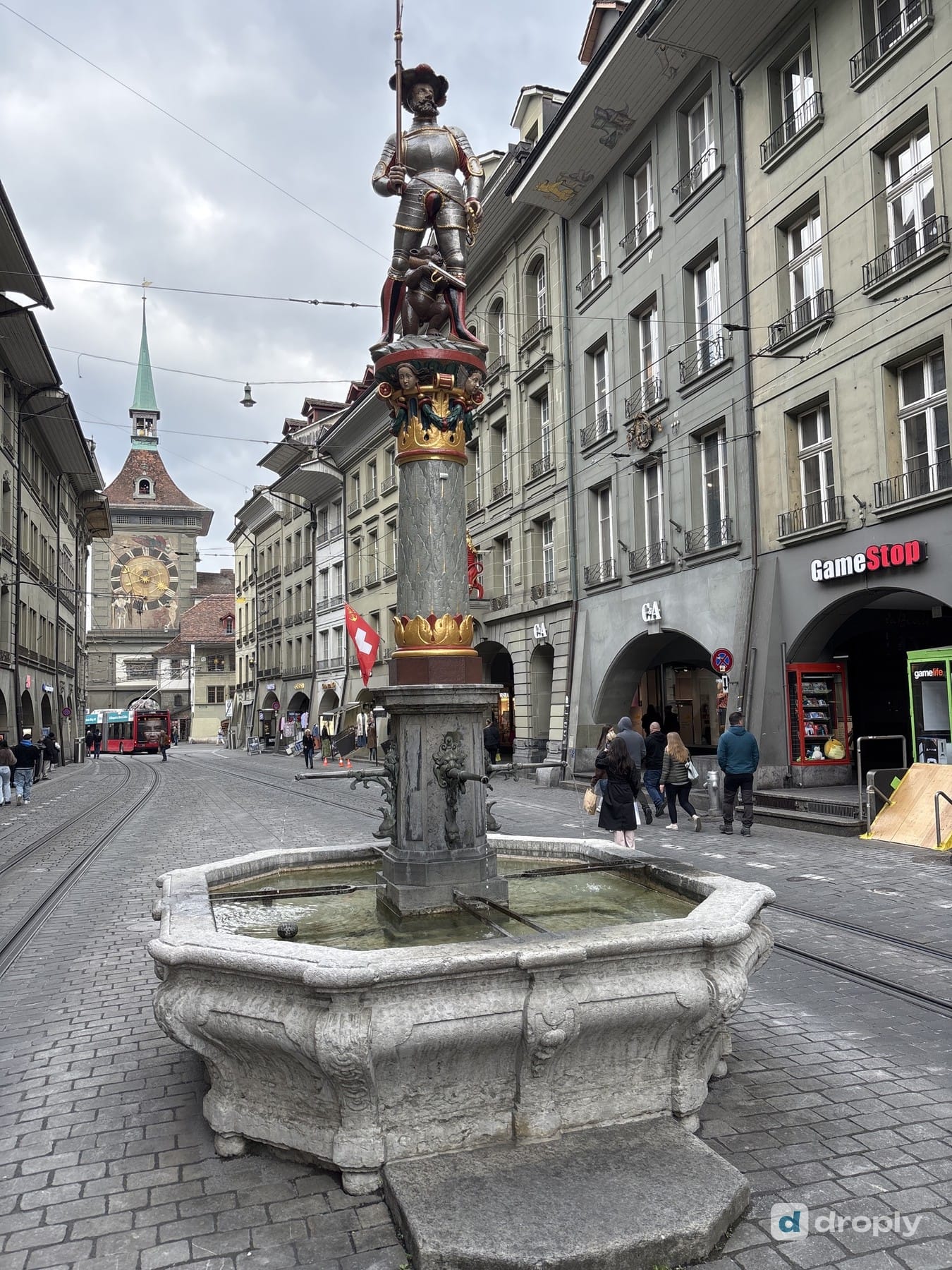 The Schützenbrunnen with a flag bearer on Marktgasse in Bern, with the Zytglogge tower in the background