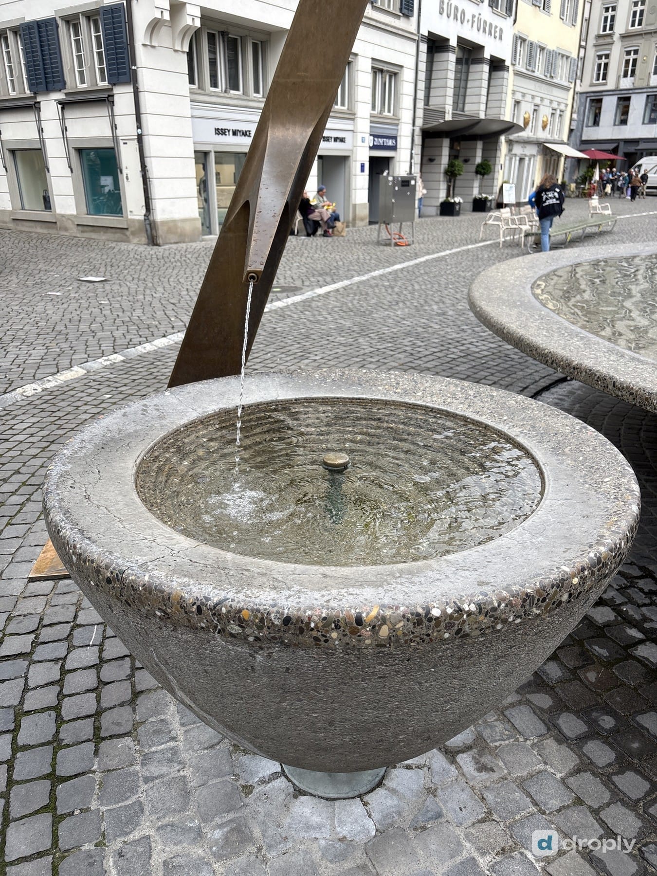 Close-up of flowing water in a modern drinking fountain at Münsterhof in Zurich