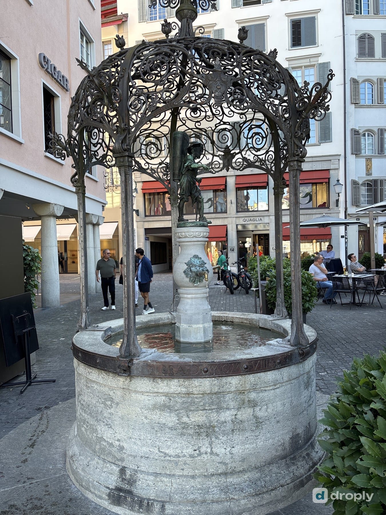 The Winzerbrunnen with an ornate wrought-iron canopy in Zurich's old town