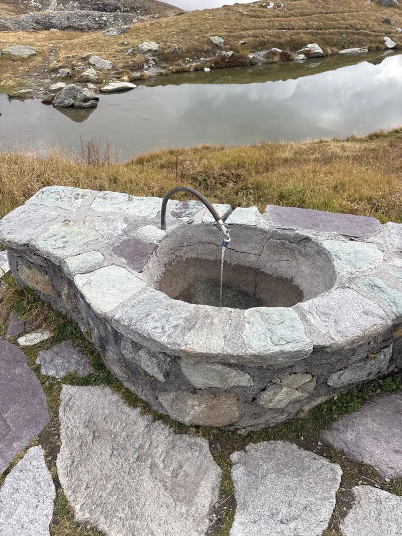 Spring water piped straight to a mountain hut tap, running all day.
